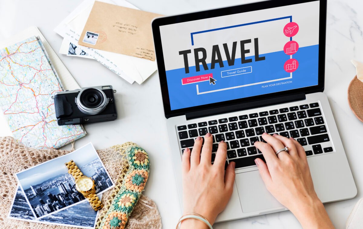 mujer viajera con ordenador buscando nuevas tendencias de viaje en 2026