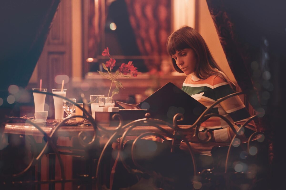 mujer viajando sola y comiendo en restaurant de noche