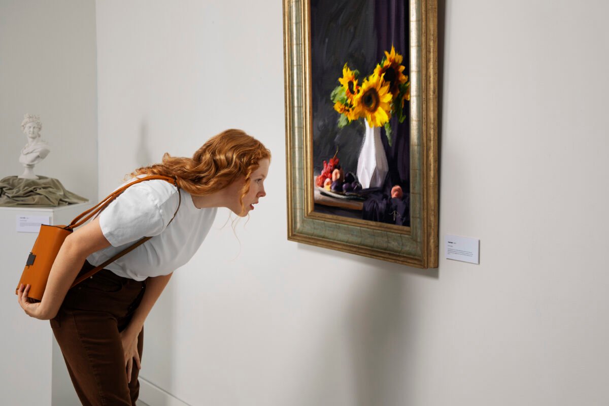 mujer viajera leyendo la explicación de un cuadro en un museo de arte